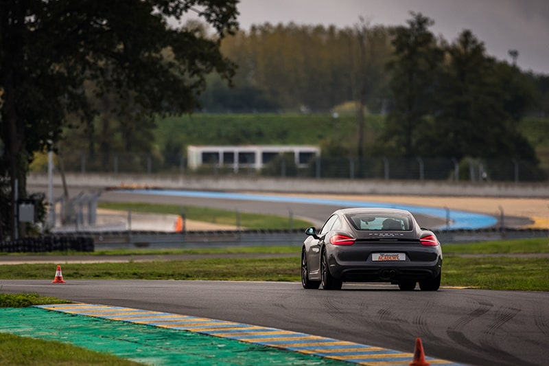 Porsche Cayman S sur le Circuit du Mans vu de derrière